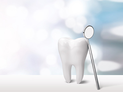 The image features a dental mirror with a toothbrush placed in it, set against a blurred background that suggests a clinical or dental office environment.