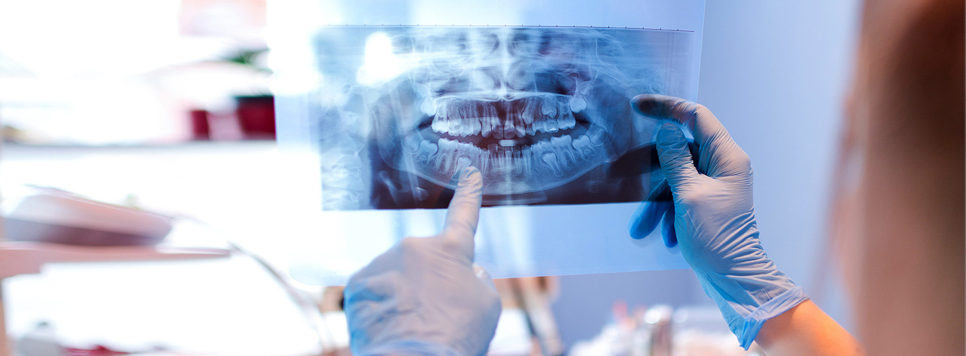 A dental professional examining a patient s teeth using a magnifying glass.